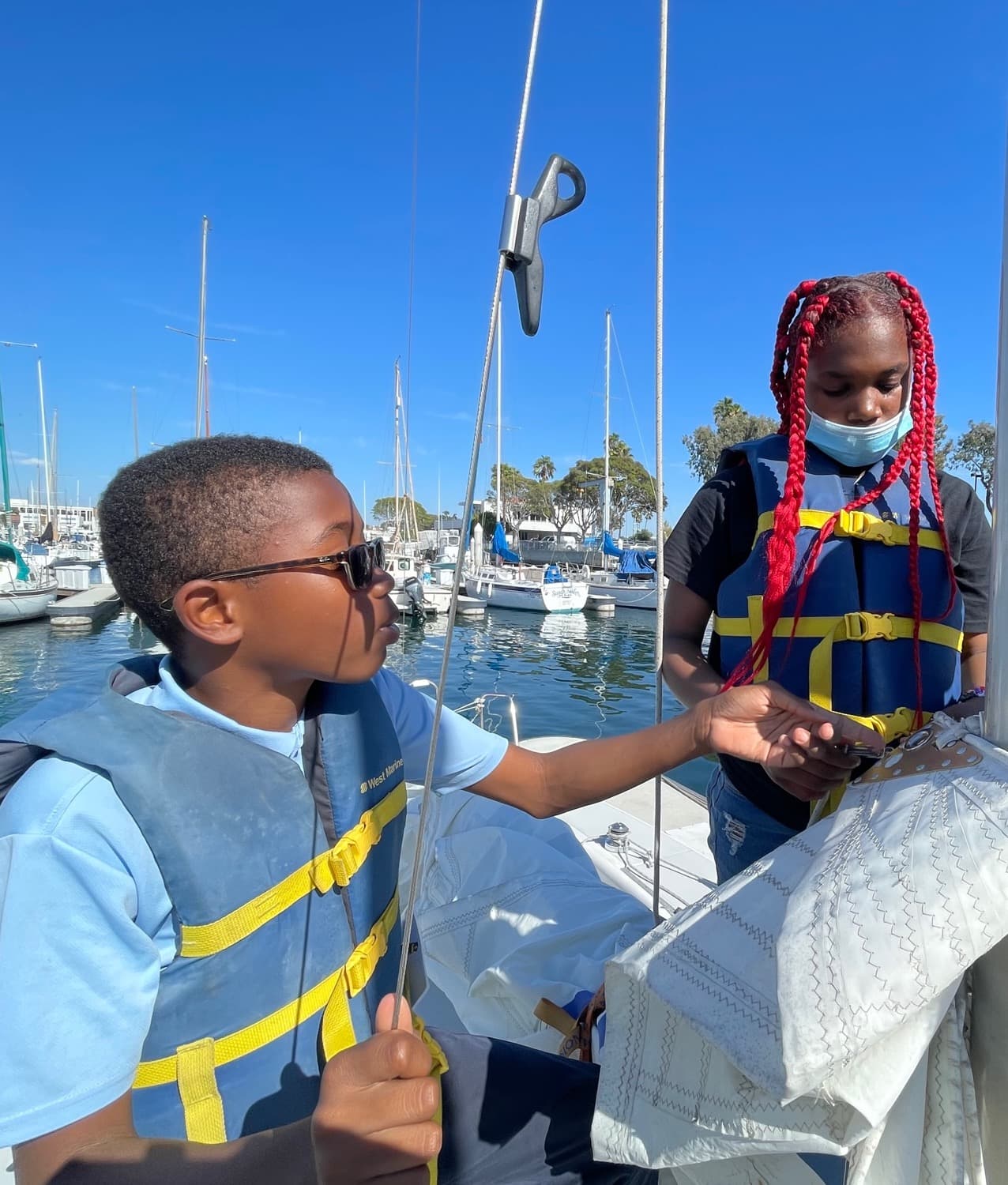 A Boys & Girls Club member hoists the main halyard
